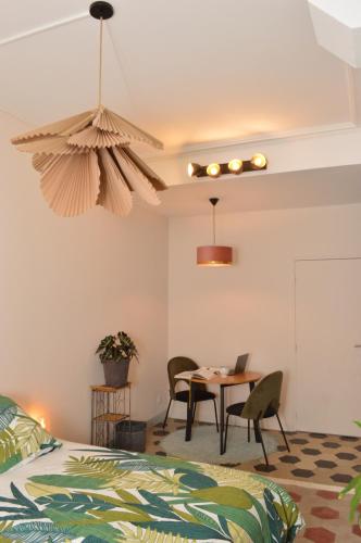 um quarto com uma mesa, cadeiras e uma cama em Studio de charme au cœur de Lyon em Lyon