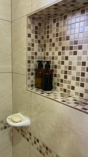 a bathroom with three vases on a tile wall at Cabañas La Suyana in Tafí del Valle