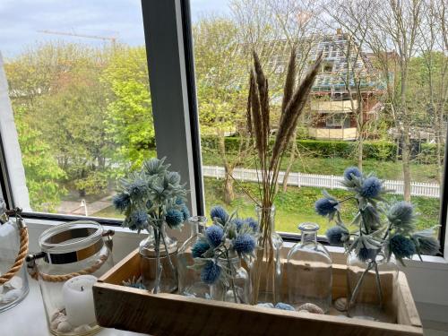 a window with vases with blue flowers in it at Res a Ros 26 in Wangerooge