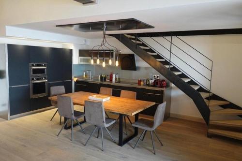 une cuisine et une salle à manger avec une table et un escalier dans l'établissement Epinette 31 Luxury appartment Duplex (9p) 4 bedrooms and 2 bathrooms., à Peisey-Nancroix