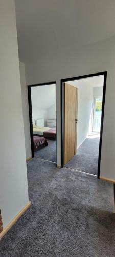 Zimmer mit 2 Spiegeln in einem Zimmer mit einem Bett in der Unterkunft Dom nad jeziorem in Wilamowo