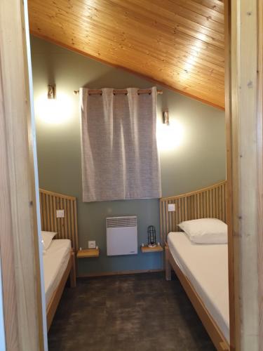 mały pokój z 2 łóżkami i oknem w obiekcie Nid Douillet w mieście Poncins