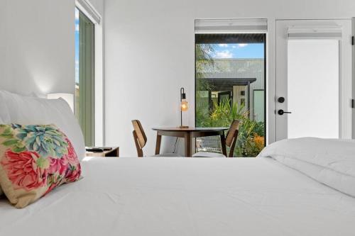 een slaapkamer met een groot wit bed en een tafel bij Modern 2-bedroom Apartment - 80 Walkscore! in Phoenix
