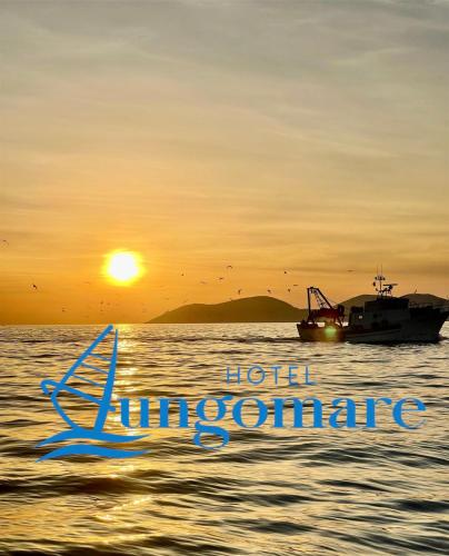 a boat in the water with a sunset in the background at Hotel Lungomare in Vlorë