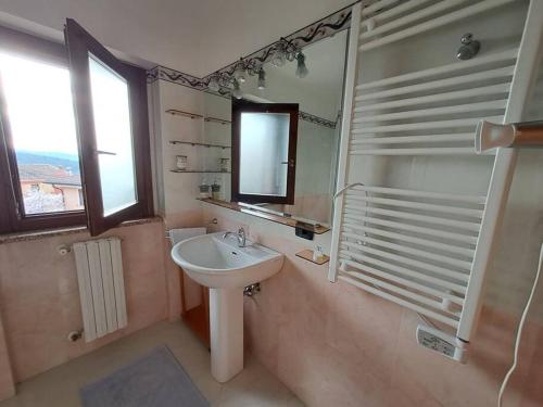 a bathroom with a sink and a mirror and a window at S'Altura, dall'alto di Nuoro in Nuoro