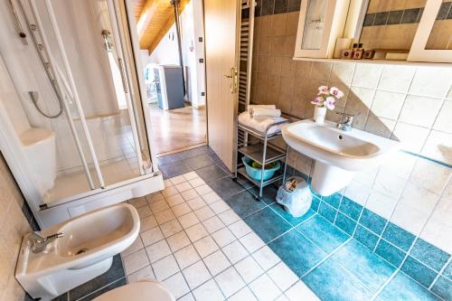 a bathroom with two sinks and a shower at Casa Panorama - Ledro House in Pieve Di Ledro