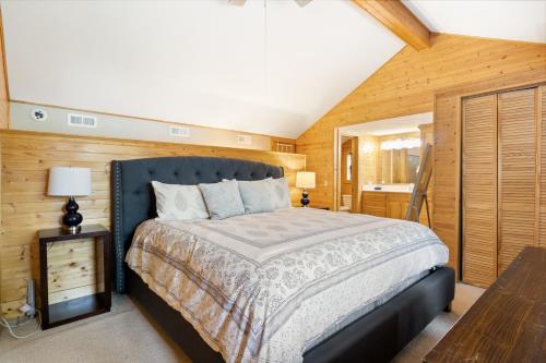 1 dormitorio con 1 cama y pared de madera en Scenic Sunset en Osage Beach