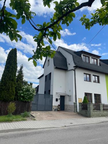a white house with a black roof at Apartment Dubnica Prejta 3 in Dubnica nad Váhom
