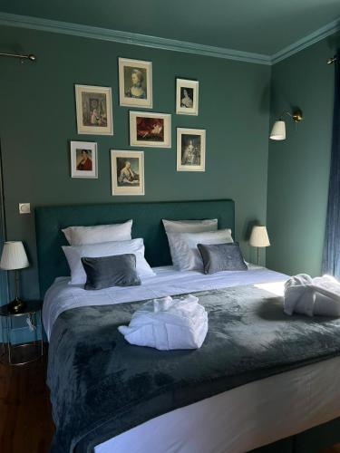 a bedroom with a large bed with green walls at Moulin de Joumard, chambres et table d'hôtes de charme , jacuzzi, sauna, piscine et bain nordique 