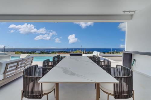 a table and chairs on a balcony with a view of the ocean at Villa Regatta in Hato