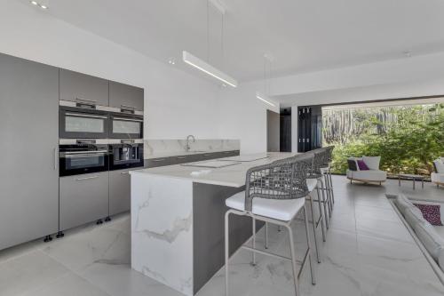 a kitchen with white appliances and a counter with stools at Villa Regatta in Hato