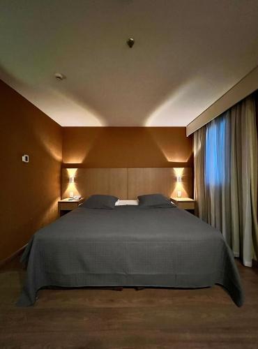 a bedroom with a large bed and a window at flat 1638 em hotel na avenida Ibirapuera - Moema in Sao Paulo