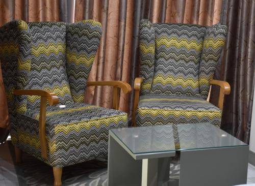 a pair of chairs and a glass table in a room at New W Hotel in Tirana
