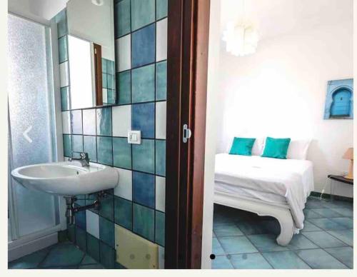 Un baño con lavabo y una cama en una habitación. en Villa Ginkò 10 posti Letto Torre Lapillo Resort 900 Mt dal Mare, en Torre Lapillo