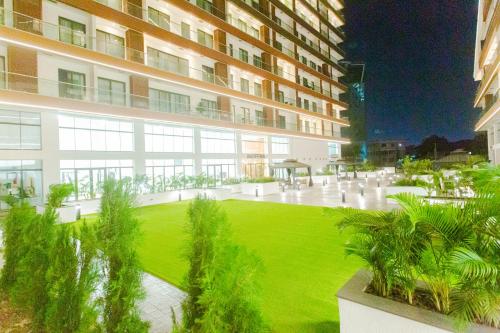 a large building with a green lawn in front of it at Accra Luxury Apartments @ The Signature in Accra