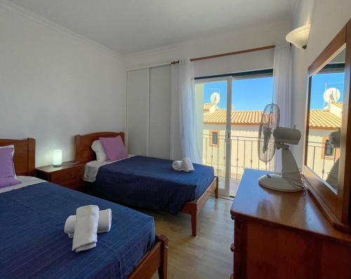 a hotel room with two beds and a balcony at Moradia T3 Aguia Marina, com piscina e BBQ in Páteo
