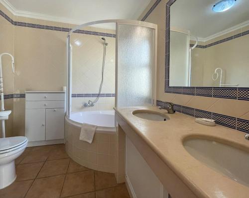 a bathroom with a tub and a sink and a toilet at Moradia T3 Aguia Marina, com piscina e BBQ in Páteo