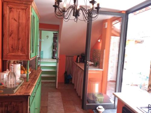 Holiday Home Carina في دولشياكا: مطبخ مع دواليب خضراء ومرآة