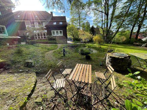 a picnic table and chairs in front of a house at Liebevoll eingerichtetes Ferienzimmer mit großen Garten in Clausthal-Zellerfeld