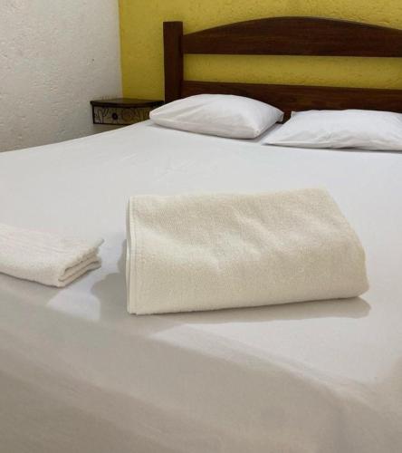 a white bed with two white towels on it at Pousada Embaubas in Serra do Cipo