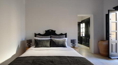 a bedroom with a large bed with a black headboard at Firalia, Casa in Rock Suites in Fira