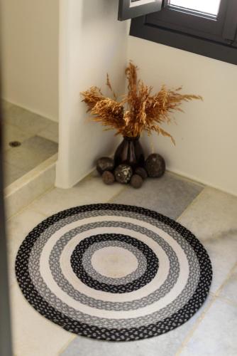 a black and white rug on a floor with a vase at Firalia, Casa in Rock Suites in Fira