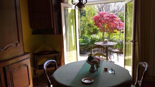 une table dans une cuisine avec vue sur un jardin dans l'établissement La maison de Léa, à Dinard