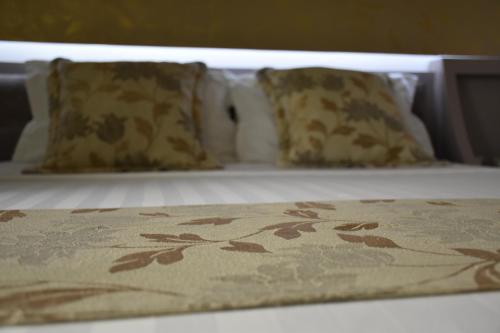 a bed with three pillows on top of it at New W Hotel in Tirana