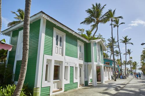 un edificio verde y blanco en una calle con palmeras en Riu Palace Bavaro - All Inclusive, en Punta Cana
