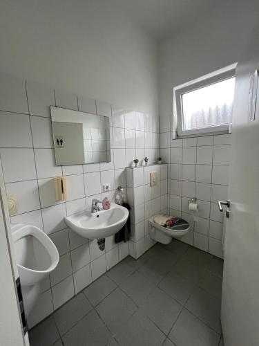 a white bathroom with a sink and a toilet at Aparts Room Hannover Centrum in Hannover