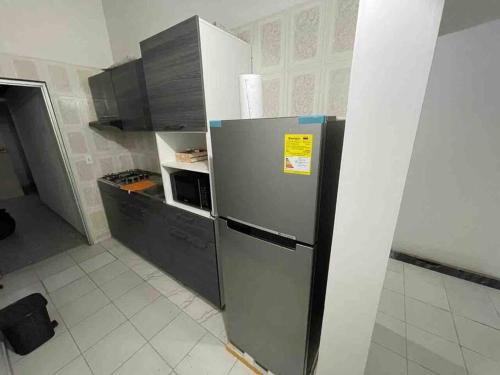 eine Küche mit einem Kühlschrank und Schränken aus Edelstahl in der Unterkunft Agradable casa en Cúcuta cerca al CC Unicentro in Cúcuta
