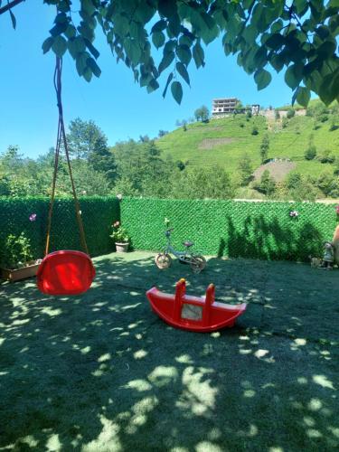 a red toy swing and a bike in a yard at Hânetül Mabeyn in Rize