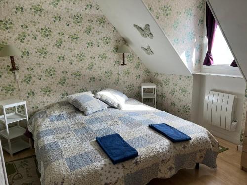 une chambre avec un lit avec des serviettes bleues dessus dans l'établissement come chez nous, à Sarlat-la-Canéda