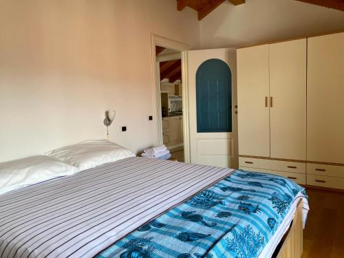 a bedroom with a bed with a blue and white bedspread at A dream on the lake in Ranco