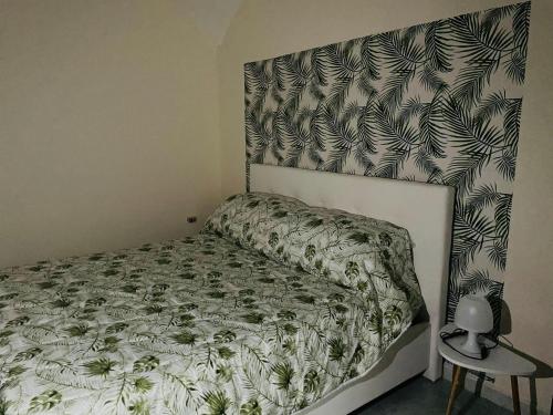 a bedroom with a bed with a green and white comforter at Al Corso 146 in Torre del Greco