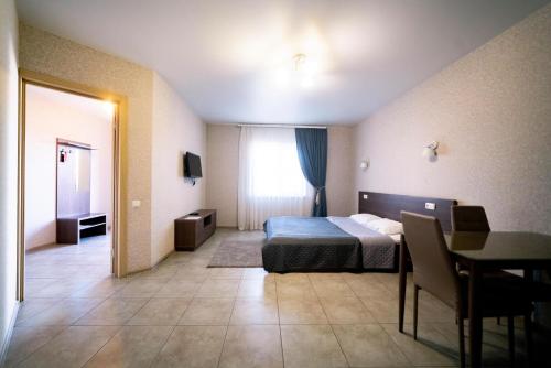 a hotel room with a bed and a table and a room at Райский Дворик in Pogreby