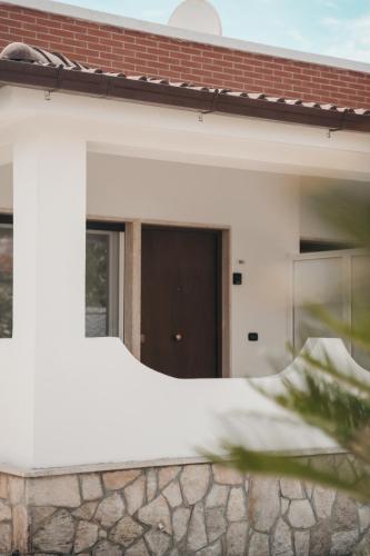 a white house with a brown door at Villa Gianna in Taranto