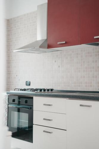 a kitchen with white cabinets and a stove top oven at Villa Gianna in Taranto