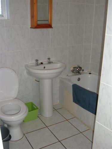 a bathroom with a sink and a toilet and a tub at Driftsands Sea View Flats in Uvongo Beach