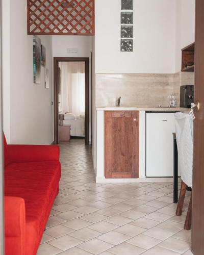 a living room with a red couch and a kitchen at Villa Gianna in Taranto
