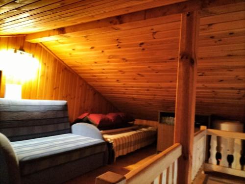 a room with a bed and a couch in a cabin at Domek nad jeziorem in Osieczna