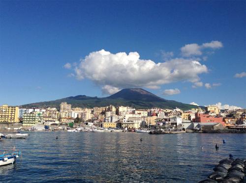 a view of a city from the water with a mountain at Al Corso 146 in Torre del Greco