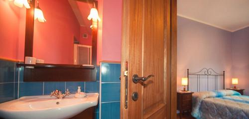 a bathroom with a sink and a mirror and a bed at I Tre Tigli - Casa di campagna in Rutino