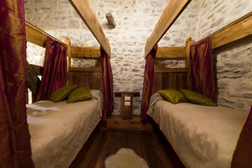 two beds in a room with red curtains at Castello di Zumelle in Mel