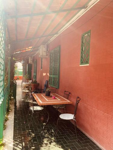 une table et des chaises installées à côté d'un mur de briques rouges dans l'établissement Villa Vitiello, à Torre Annunziata