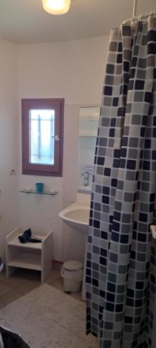 La salle de bains est pourvue d'une baignoire et d'un rideau de douche. dans l'établissement Barcarès île des pêcheurs hébergement insolite cosy et tout confort classé 4 étoiles, au Barcarès