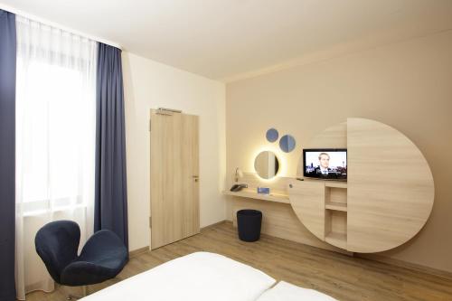 a bedroom with a bed and a round mirror at H2 Hotel Berlin-Alexanderplatz in Berlin