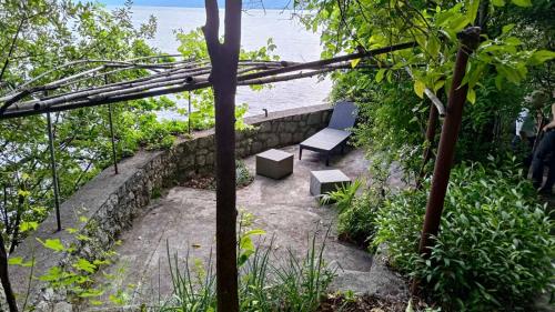 a bench in a garden with a view of the ocean at Aparatman Residence in Rijeka