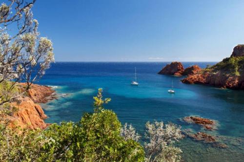 a view of a bay with boats in the water at Dans un cadre d'exception, Vue mer panoramique à Agay Côte d'Azur, Village Vacances Cap Esterel, 2 chambres, avec jardin, golf, climatisation, Wifi, 5 piscines in Agay - Saint Raphael