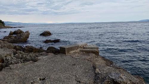 a group of steps on the rocks near the water at Aparatman Residence in Rijeka